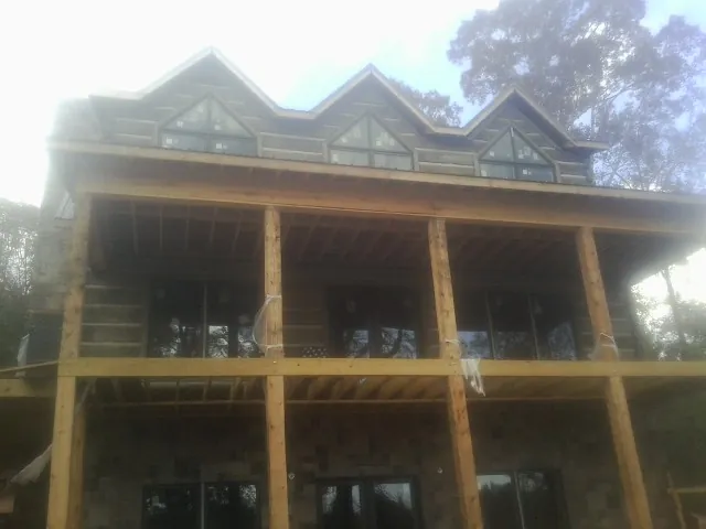 Dormers and porch framing on a large log home under construction — Roof Coating work by our crew in Birdsboro