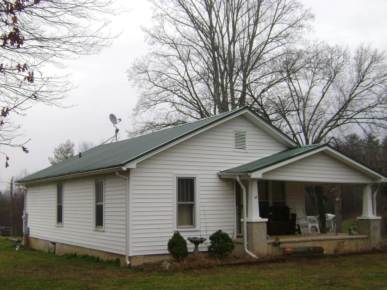 Green metal roof on a white bungalow with a side porch in Birdsboro