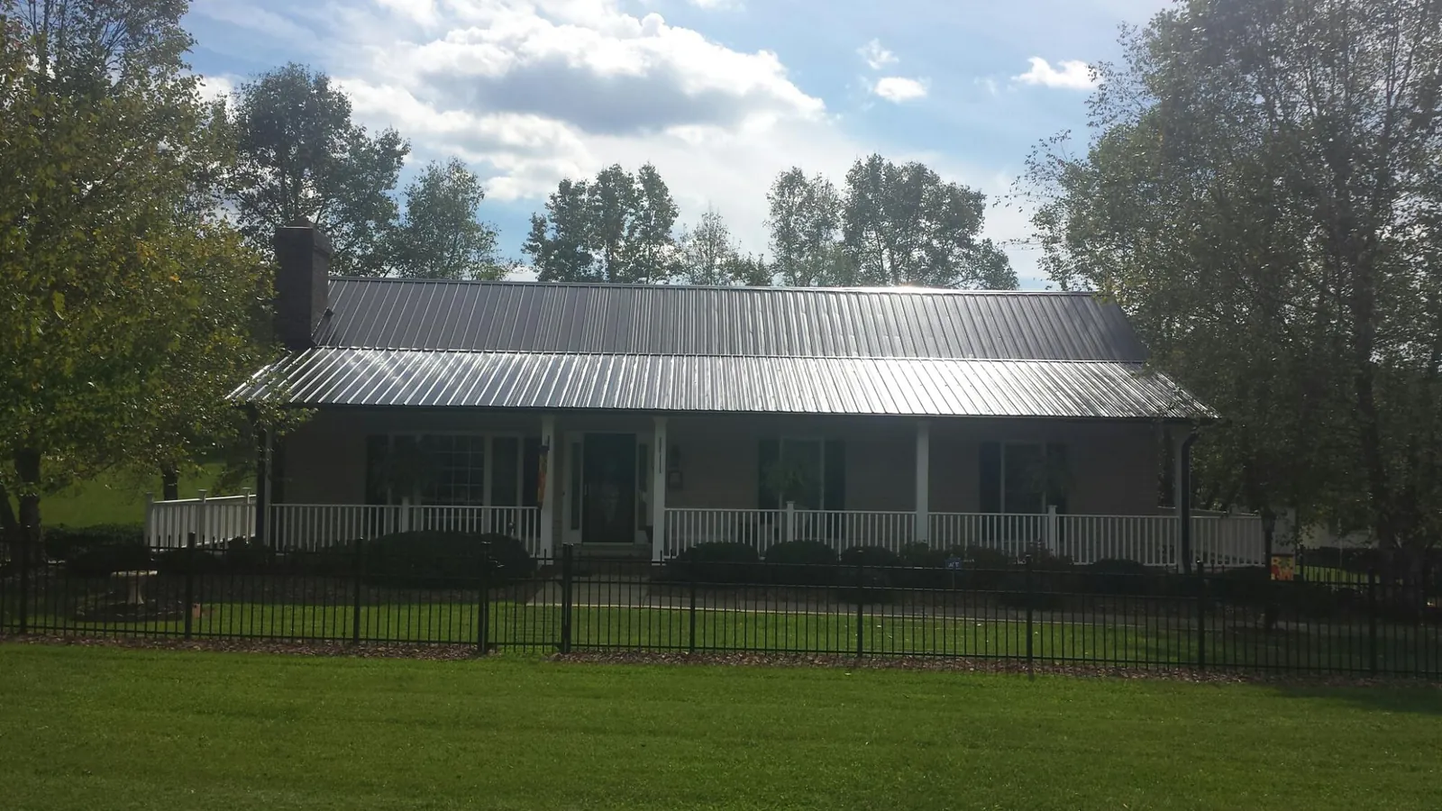Gray metal roof on a brick ranch with a full width front porch — Gutter Guard Installation work by our crew in Birdsboro