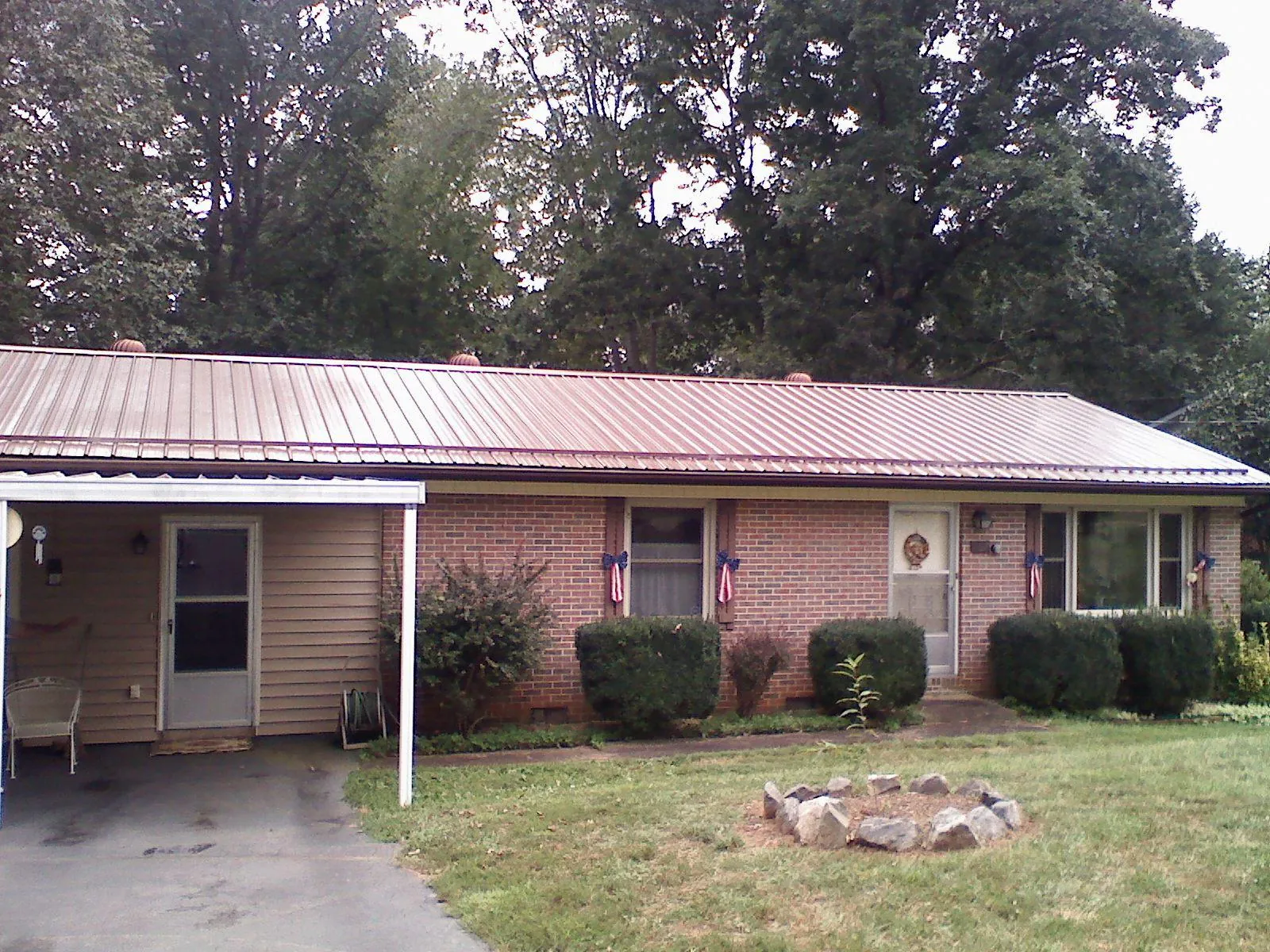 Bronze metal roof and carport on a brick ranch home — Roof Repair work by our crew in Birdsboro